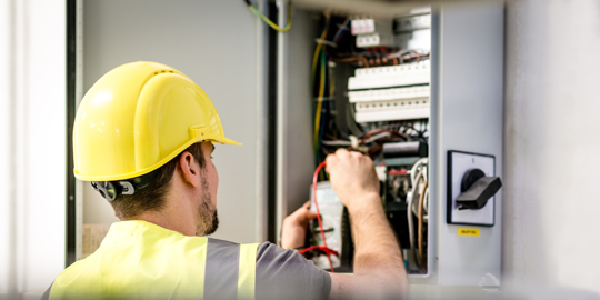 An electrician fixing the wires in the electrical box